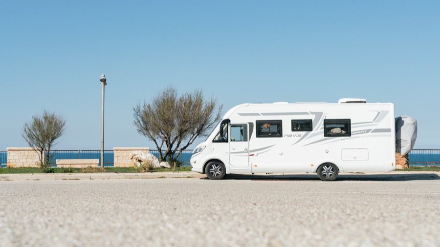 Un camping-car profilé blanc garé au bord de la mer